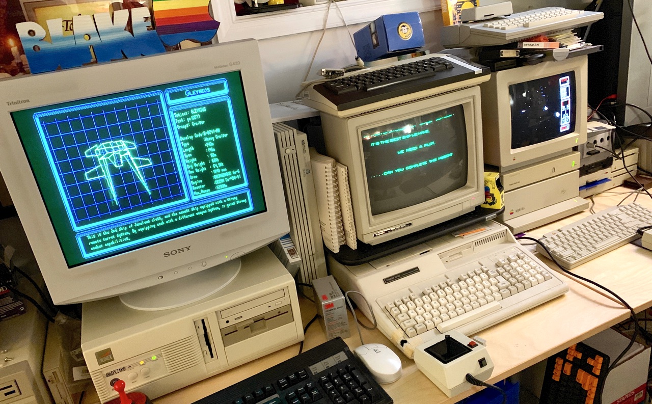 Photo of desk with two DOS PCs and an Apple IIgs, all running Silpheed